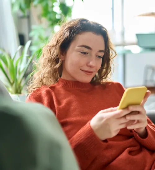 Customer smiling and leaving a five-star review on her phone after service.