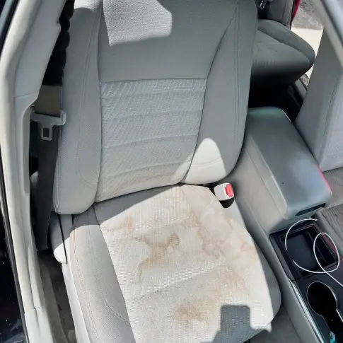 On-site before car seat washing, technician assessing stains and fabric type