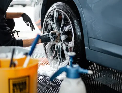 Technician finishing a full exterior and interior detail on a compact car.