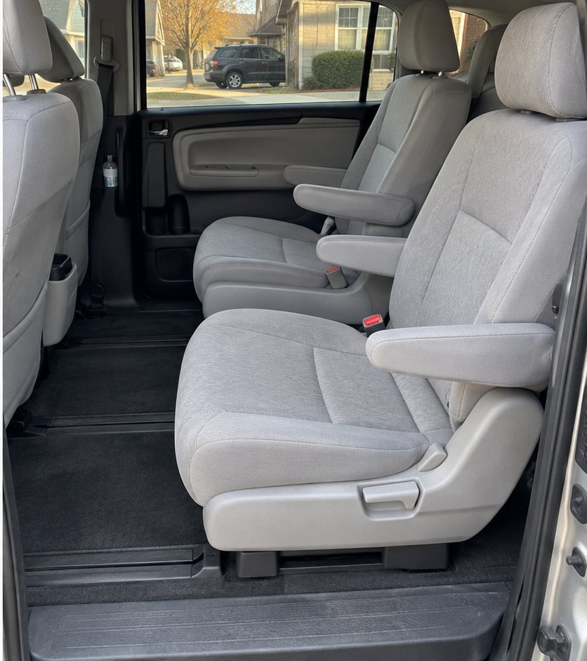 The same minivan second-row captain's chairs and floor fully vacuumed and wiped down with no visible debris